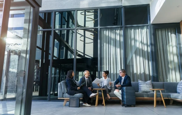 Four Bay Street banking professionals meeting in quiet hallway to discuss Portfolio+
