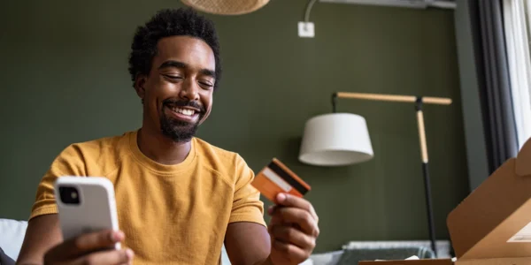 Young man reviews transactions history using Canadian retail bank card and a banks financial technology.