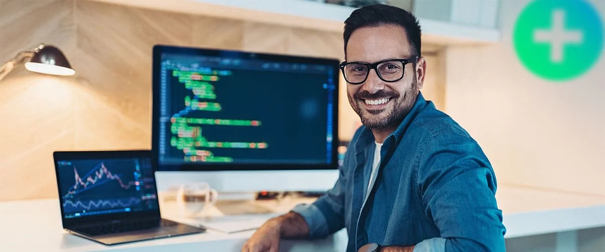 Portfolio+ Expert smiling with coding dashboard on screen